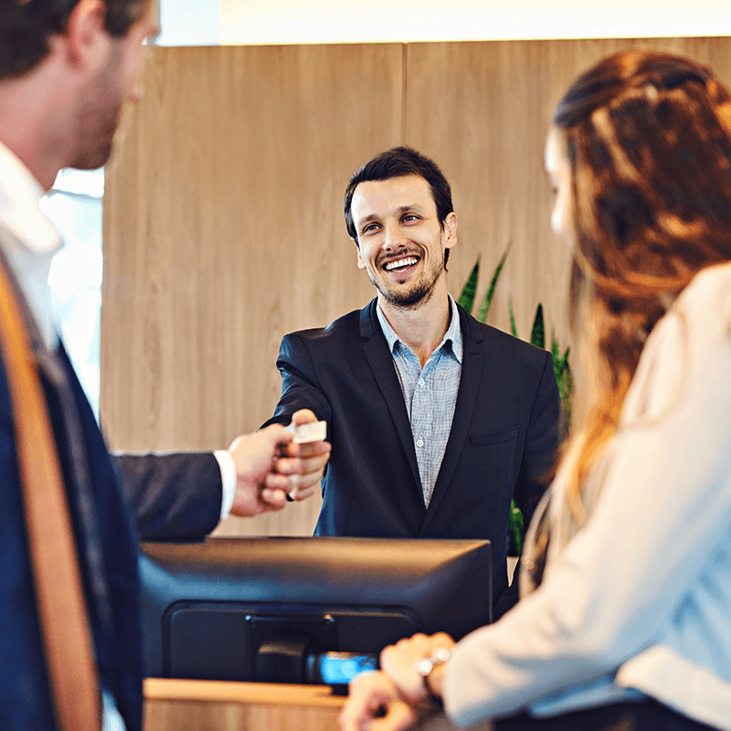 Hotel receptionist smiling at guests